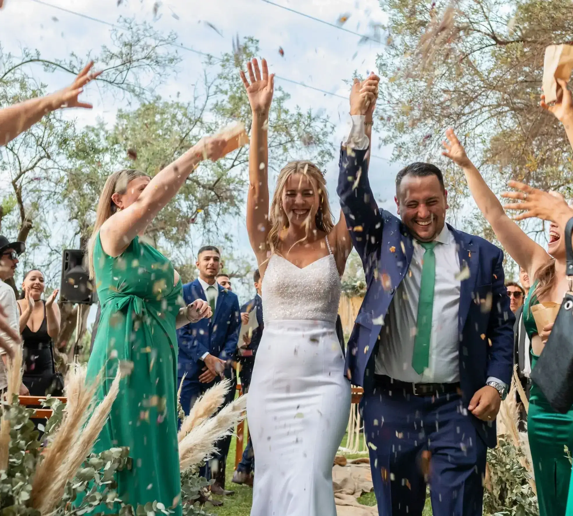 Guests throwing confetti as the couple walk through